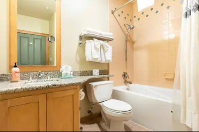 a bathroom with a toilet and a tub and a sink at Juniper Springs Lodge 437 in Mammoth Lakes