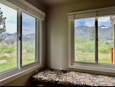 a bedroom with two windows and a bed with a view at Mammoth Creek 29 in Mammoth Lakes