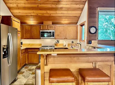 a kitchen with wooden cabinets and a stainless steel refrigerator at Snowcreek 290 in Mammoth Lakes