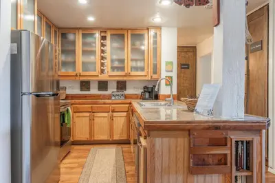a kitchen with wooden cabinets and a stainless steel refrigerator at Summit 33 in Mammoth Lakes