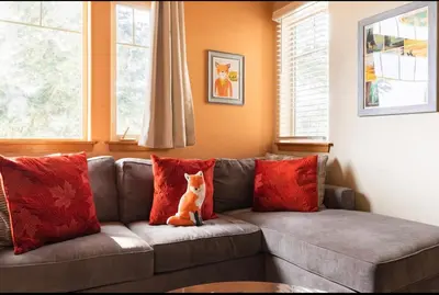 a cat sitting on a couch with red pillows at Gray Eagle 5 in Mammoth Lakes