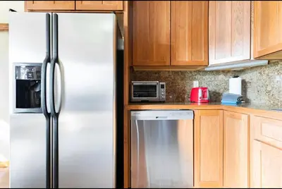 a kitchen with a white refrigerator and wooden cabinets at Gray Eagle 5 in Mammoth Lakes