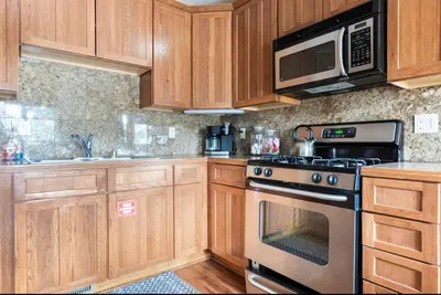 a kitchen with wooden cabinets and a stove and microwave at Gray Eagle 5 in Mammoth Lakes