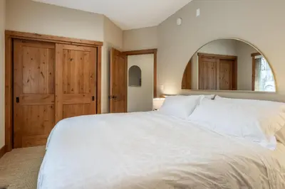 a bedroom with a large white bed and a mirror at Stonegate 11 in Mammoth Lakes