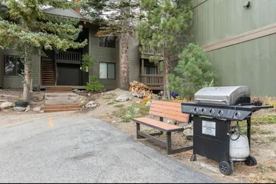 a grill and a bench in front of a house at Seasons Four 165 in Mammoth Lakes