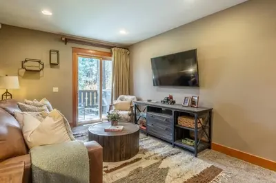 a living room with a couch and a tv at Timbers 1031 in Mammoth Lakes