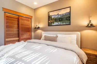 a bedroom with a large white bed and a window at Timbers 1031 in Mammoth Lakes