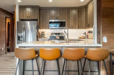 a kitchen with a counter with four bar stools at Canyon Ski and Racquet 3 in Mammoth Lakes