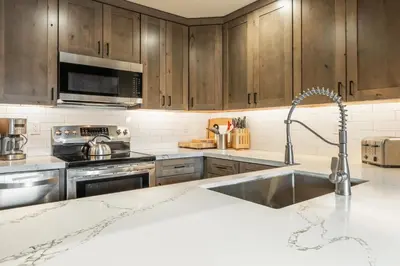 a kitchen with wooden cabinets and a stainless steel sink at Canyon Ski and Racquet 3 in Mammoth Lakes