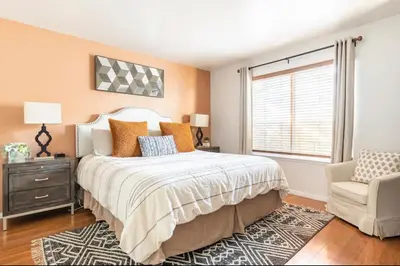a bedroom with a bed and a chair and a window at Seasons Four 193 in Mammoth Lakes