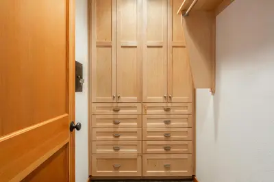 a closet with wooden cabinets next to a door at Snowflower 21 in Mammoth Lakes