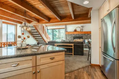 a kitchen with a refrigerator and a living room at Snowflower 21 in Mammoth Lakes
