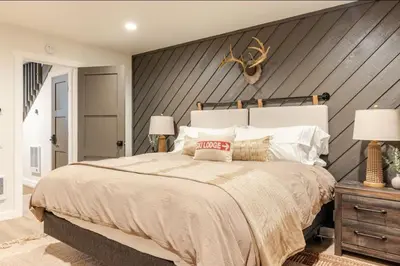 a bedroom with a large bed with a wooden wall at Snowcreek 25 in Mammoth Lakes