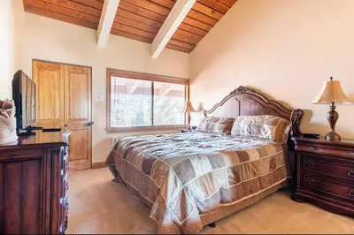 a bedroom with a bed and a dresser and a television at Mammoth Ski and Racquet 89 in Mammoth Lakes
