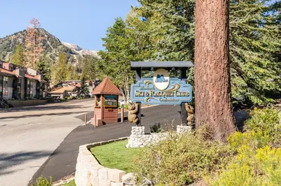 a sign for a snowmobiling club next to a tree at Mammoth Ski and Racquet 89 in Mammoth Lakes