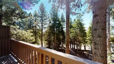 a wooden deck with a view of a forest at Mammoth View Villas 32 in Mammoth Lakes