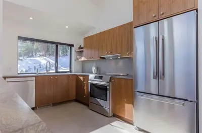 a kitchen with wooden cabinets and a stainless steel refrigerator at 88 Bridges Lane in Mammoth Lakes