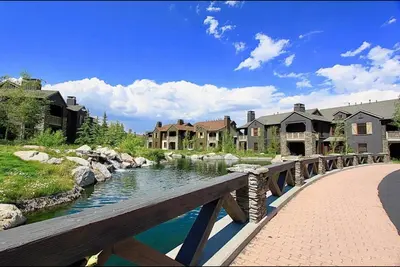 a bridge over a river next to a group of houses at Lodges 1129 in Mammoth Lakes