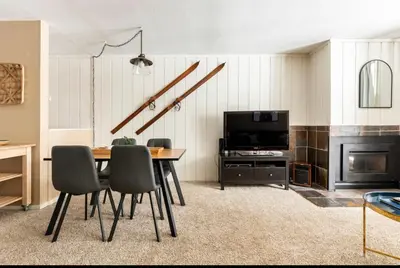 a dining room with a table and chairs and a tv at Crestview 45 in Mammoth Lakes