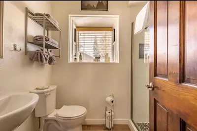 a bathroom with a toilet and a sink and a mirror at Forest Creek 21 in Mammoth Lakes
