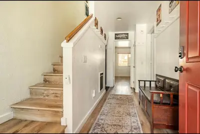 a hallway with stairs and a red door at Forest Creek 21 in Mammoth Lakes