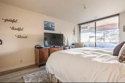 a bedroom with a bed and a flat screen tv at Bridges 210 in Mammoth Lakes