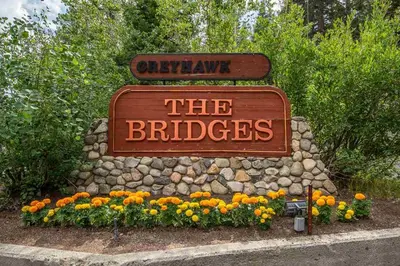 a sign for the bridles at a park with flowers at Bridges 210 in Mammoth Lakes