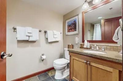 a bathroom with a toilet and a sink and a mirror at Everline Resort & Spa 536 in Olympic Valley