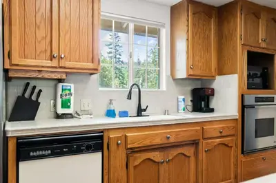 a kitchen with wooden cabinets and a sink at Whispering Pines in Oakhurst