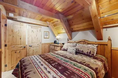 a bedroom with a bed and wooden ceilings at Cabin on Ralph in South Lake Tahoe