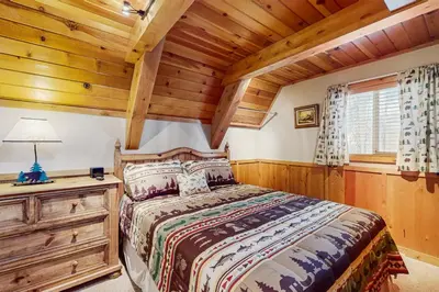 a bedroom with a bed and a wooden ceiling at Cabin on Ralph in South Lake Tahoe