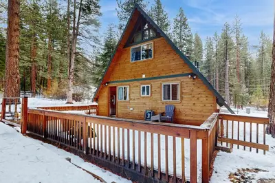 a log cabin with a deck in the snow at Cabin on Ralph in South Lake Tahoe