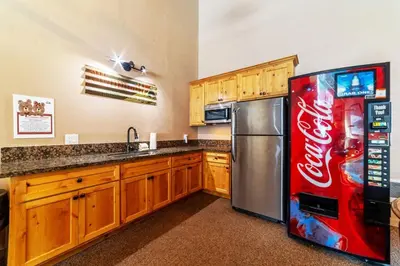 a kitchen with a cocacola refrigerator and a sink at Ski In Canyon Lodge Modern 1 bdrm Pacman and Garage in Mammoth Lakes