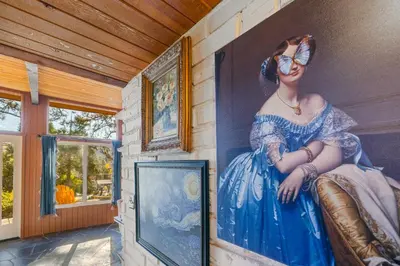 a painting of a woman in a blue dress on a wall at 16 mi to Yosemite-1 mi to Oakhurst-Anthro Decor in Oakhurst