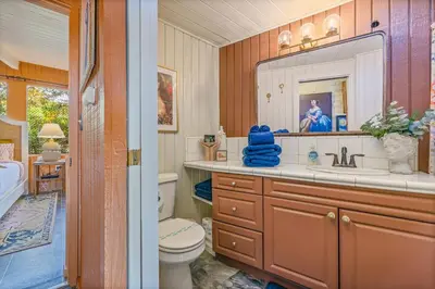 a bathroom with a sink and a toilet and a mirror at 16 mi to Yosemite-1 mi to Oakhurst-Anthro Decor in Oakhurst