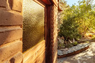 a glass door on a brick building with a fence at 16 mi to Yosemite - Rustic Studio - Hiking Nearby in Oakhurst