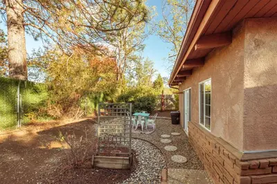 a backyard with a table and a fence and a patio at 16 mi to Yosemite - Rustic Studio - Hiking Nearby in Oakhurst
