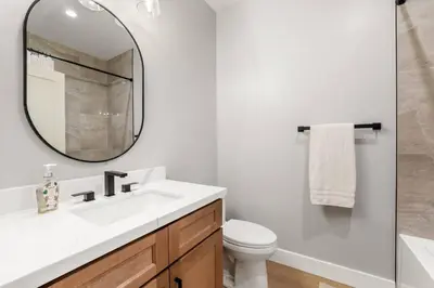 a white bathroom with a sink and a mirror at Tahoe Toasty - 3 Bedroom Home Near Sledding Hill in South Lake Tahoe