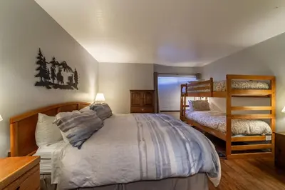 a bedroom with a large bed and a chair at Adventure by Day Cozy Nights Family Alpine Condo in Mammoth Lakes