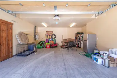 an empty garage with a table and a refrigerator at 2 Luxury Adjacent Northstar Homes Walk to Lifts Private Hot Tubs in Truckee