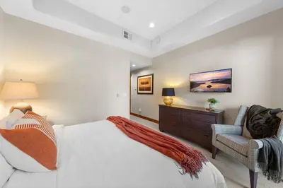 a bedroom with a bed and a chair and a dresser at 2 Luxury Adjacent Northstar Homes Walk to Lifts Private Hot Tubs in Truckee