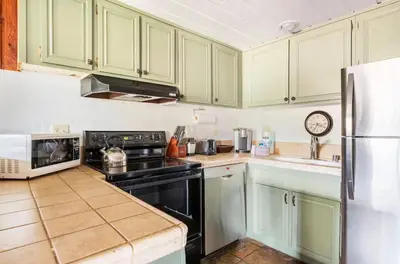 a kitchen with green cabinets and a black stove at Val DIsere 27 in Mammoth Lakes