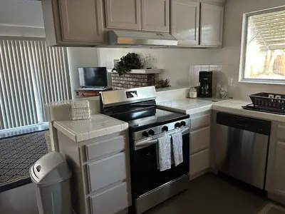 a kitchen with white cabinets and a stove top oven at Turlocks Little Palace in Turlock