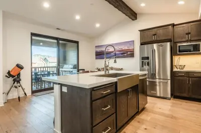 a kitchen with a sink and a refrigerator at Mammoth Refuge Rustic Creekhouse Retreat in Mammoth Lakes