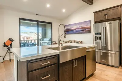 a kitchen with a sink and a refrigerator at Mammoth Refuge Rustic Creekhouse Retreat in Mammoth Lakes