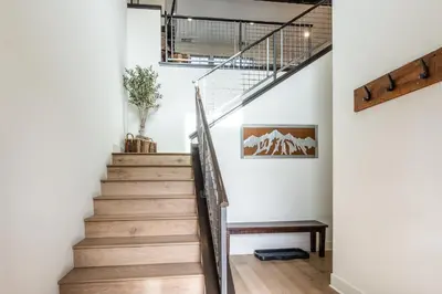 a staircase in a home with white walls and wooden floors at Mammoth Refuge Rustic Creekhouse Retreat in Mammoth Lakes