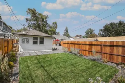 a backyard with a fence and a house at Pet-Friendly Private Cottage In Tahoe Park in Sacramento