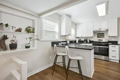 a kitchen with white cabinets and a black counter top at Pet-Friendly Private Cottage In Tahoe Park in Sacramento