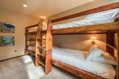 a bedroom with two bunk beds in a house at Painted River Retreat by Tahoe Getaways - 4BR w River Views, Hot Tub & EV Charger. in Truckee