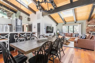 a dining room and living room with a table and chairs at Chateau Sans Nom 30 in Mammoth Lakes